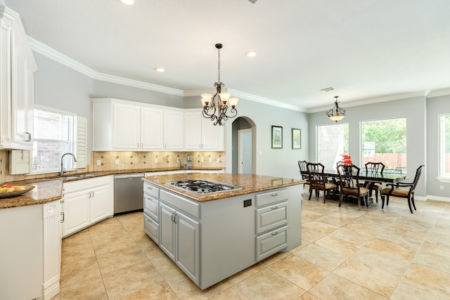 kitchen with stainless steel appliances, a center island, decorative light fixtures, and white cabinets