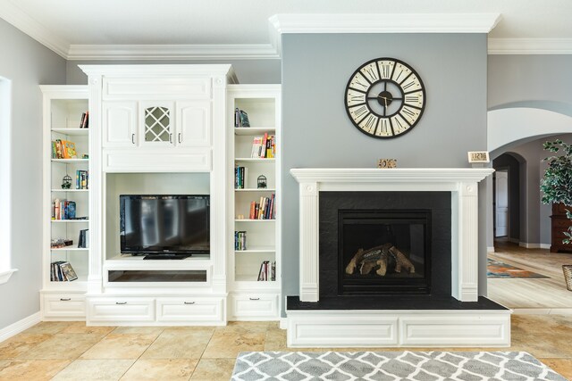 unfurnished living room featuring ornamental molding, built in features, and light tile patterned floors