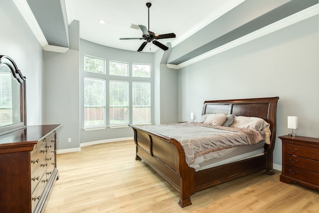 bedroom featuring ceiling fan, crown molding, multiple windows, and light wood-type flooring