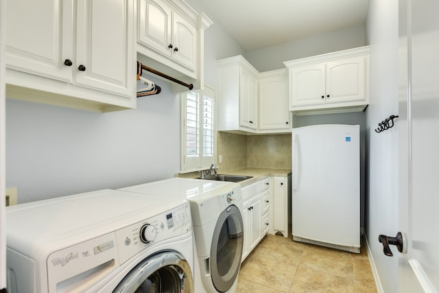 laundry room with light tile patterned flooring, washing machine and dryer, sink, and cabinets