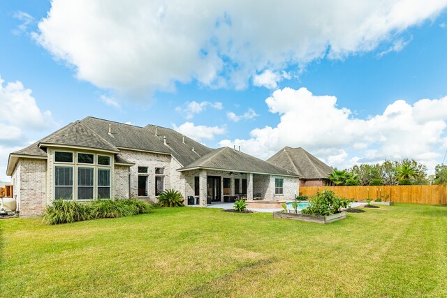 rear view of house featuring a yard and a patio area