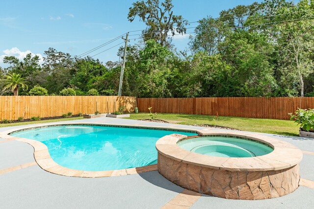 view of pool featuring an in ground hot tub and a lawn