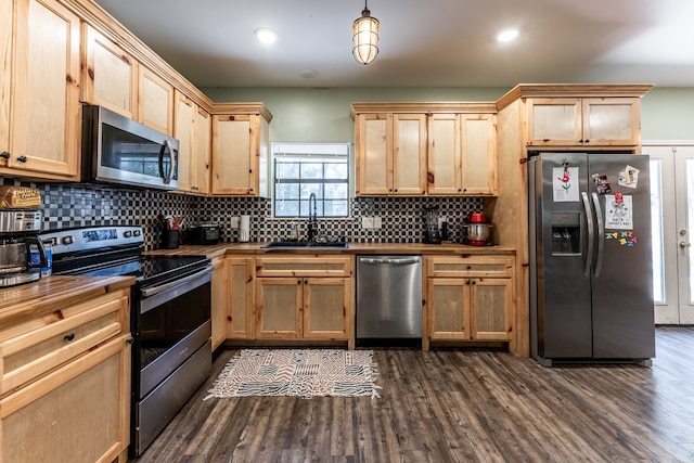 kitchen featuring light brown cabinets, dark wood-type flooring, stainless steel appliances, sink, and decorative light fixtures