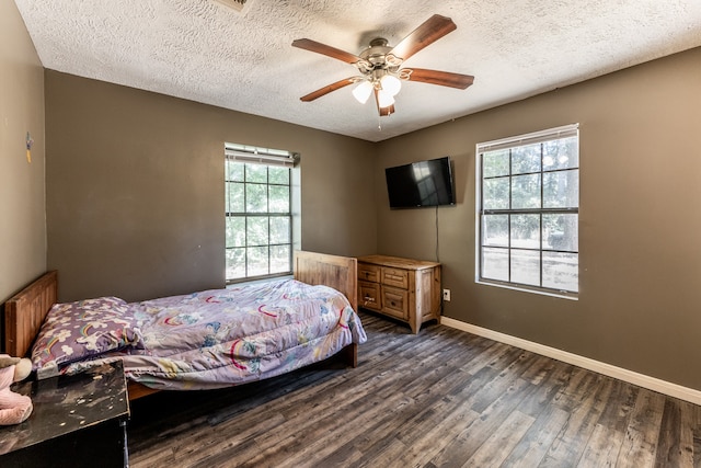 bedroom with dark hardwood / wood-style flooring, a textured ceiling, multiple windows, and ceiling fan