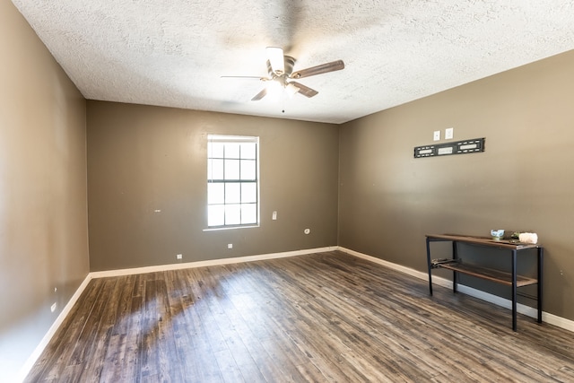 unfurnished room featuring dark wood-type flooring, ceiling fan, and a textured ceiling