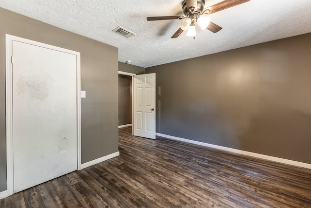 unfurnished bedroom with ceiling fan, a textured ceiling, and dark hardwood / wood-style flooring