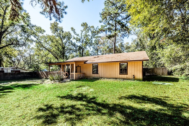 rear view of house featuring a yard