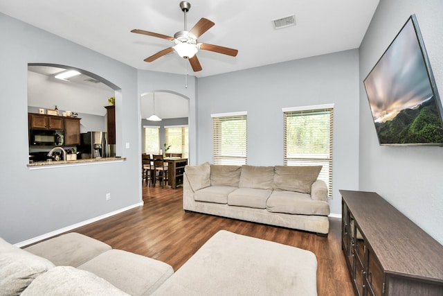 living room with ceiling fan and dark hardwood / wood-style flooring