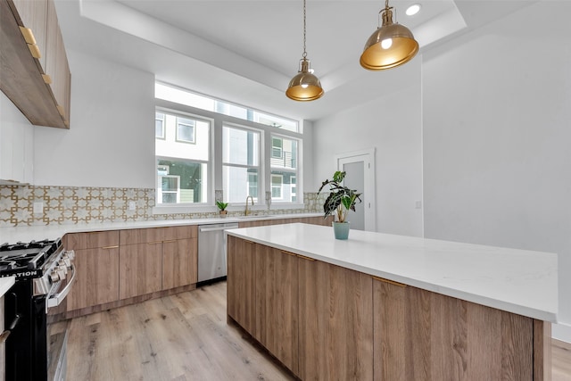kitchen with light countertops, a sink, modern cabinets, and stainless steel appliances