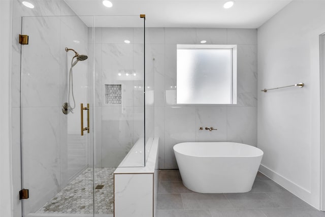 full bath featuring a soaking tub, recessed lighting, and a marble finish shower