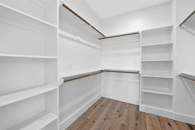 walk in closet with wood finished floors