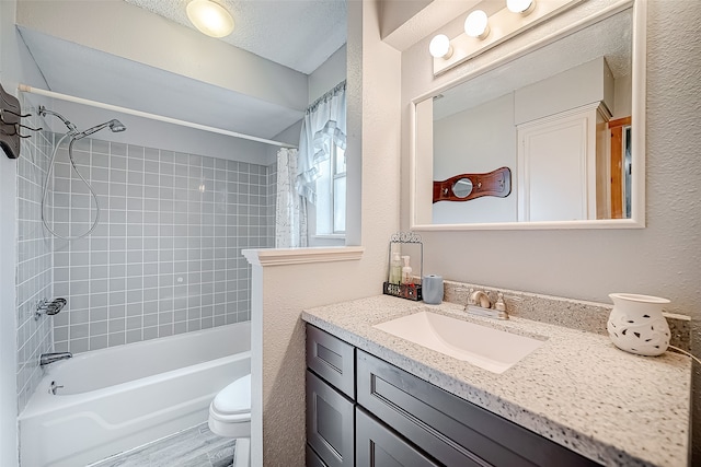 full bathroom featuring wood-type flooring, a textured ceiling, toilet, vanity, and shower / tub combo