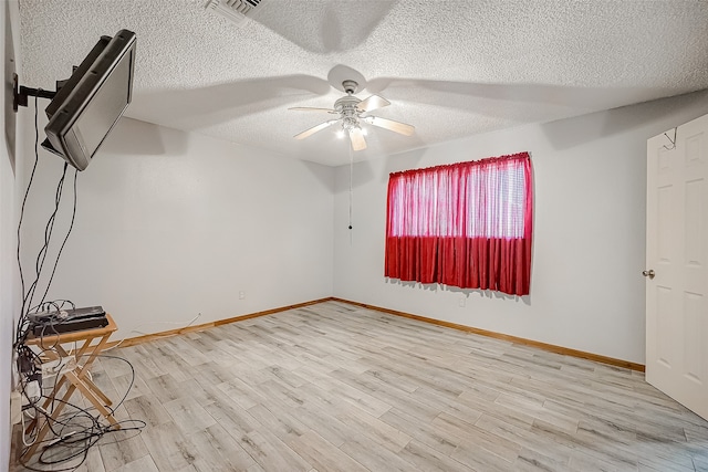 spare room with ceiling fan, a textured ceiling, and hardwood / wood-style flooring