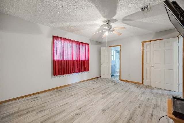 unfurnished bedroom featuring connected bathroom, ceiling fan, a textured ceiling, a closet, and light wood-type flooring