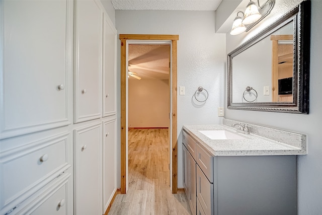 bathroom featuring vanity, hardwood / wood-style floors, and a textured ceiling