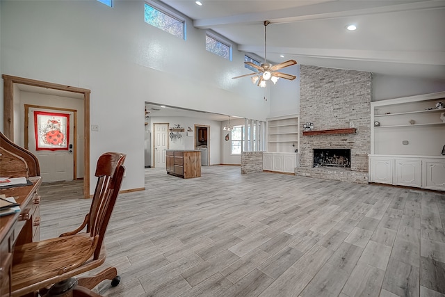 unfurnished living room featuring beam ceiling, built in shelves, ceiling fan, high vaulted ceiling, and a fireplace