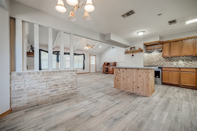 kitchen with backsplash, ceiling fan with notable chandelier, lofted ceiling with beams, stainless steel range oven, and a kitchen island