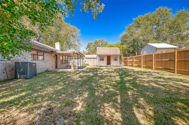 view of yard featuring a shed and central AC