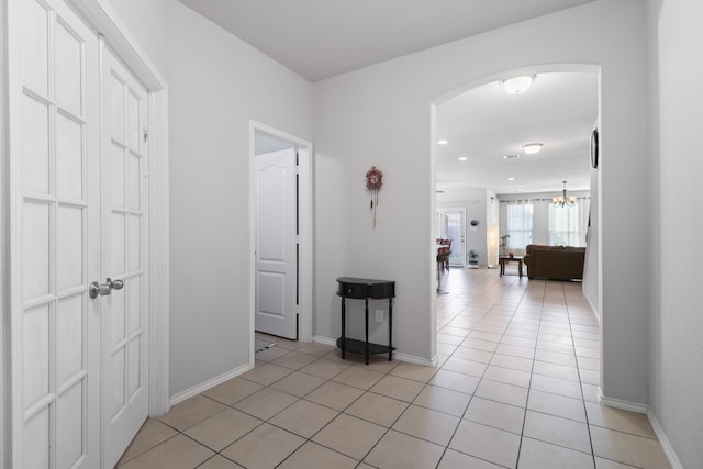 hall with an inviting chandelier and light tile patterned floors