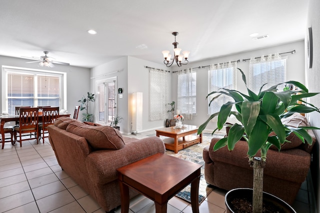 living room with ceiling fan with notable chandelier and light tile patterned floors