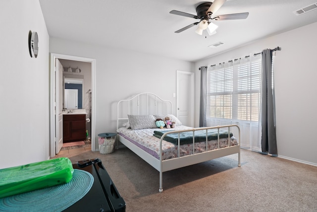 carpeted bedroom with ensuite bathroom and ceiling fan