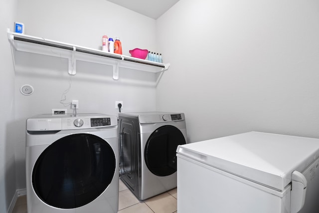 washroom with independent washer and dryer and light tile patterned flooring