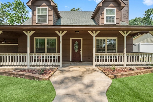 view of front of home with covered porch, a front yard, and ceiling fan