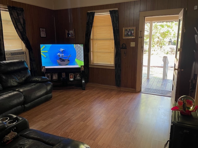 living room featuring cooling unit, hardwood / wood-style flooring, and wooden walls