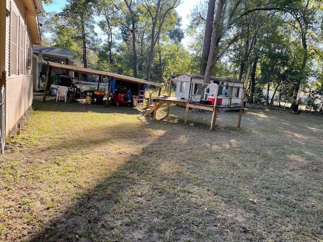 view of yard with a wooden deck and a carport