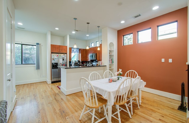 dining area with light hardwood / wood-style floors and plenty of natural light