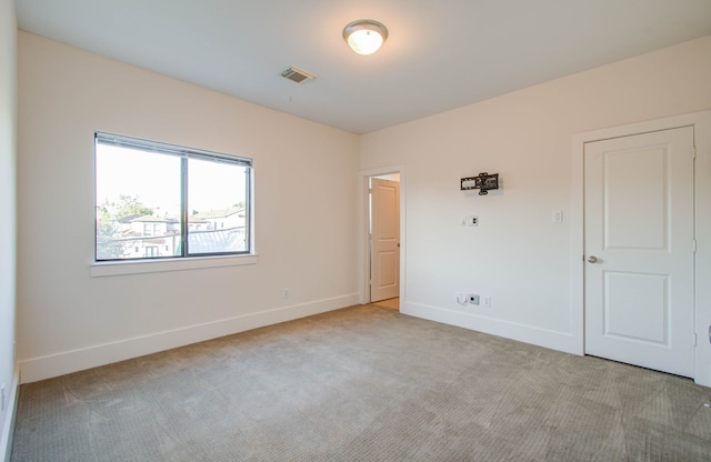 spare room featuring light colored carpet