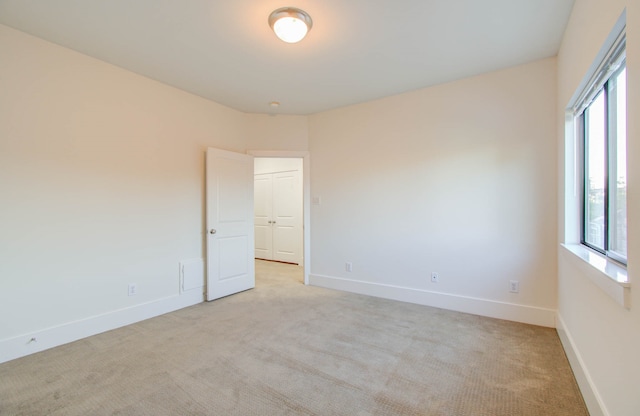 carpeted spare room featuring plenty of natural light