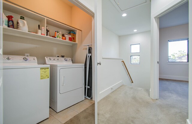 laundry area featuring light carpet and washer and clothes dryer