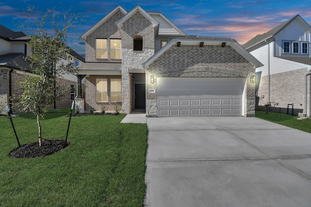 view of front of home with a garage and a lawn