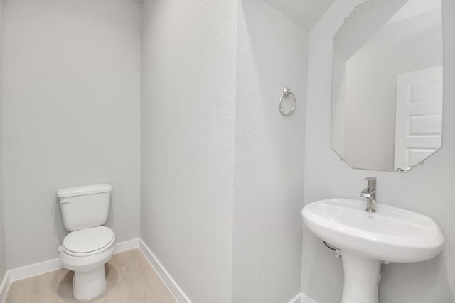 bathroom with toilet, hardwood / wood-style flooring, and sink