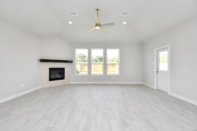 unfurnished living room featuring lofted ceiling, light hardwood / wood-style flooring, ceiling fan, and plenty of natural light