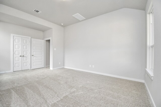 unfurnished bedroom featuring a closet, lofted ceiling, and carpet floors