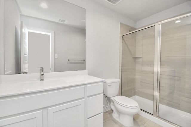 bathroom featuring vanity, toilet, and walk in shower