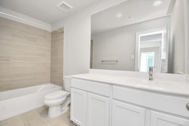 full bathroom featuring vanity, tiled shower / bath combo, and toilet