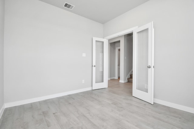 unfurnished bedroom featuring french doors and light hardwood / wood-style flooring