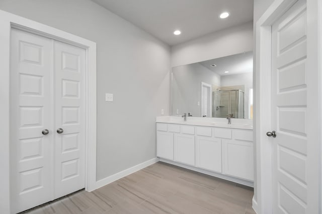 bathroom featuring a shower with door, vanity, and hardwood / wood-style floors