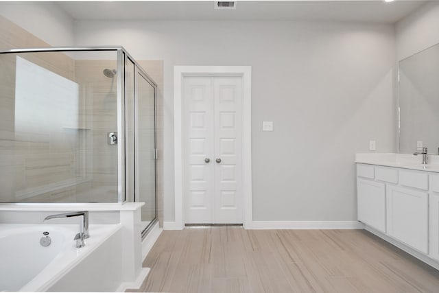 bathroom with vanity, hardwood / wood-style flooring, and separate shower and tub