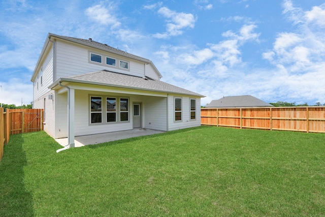 rear view of house featuring a yard and a patio