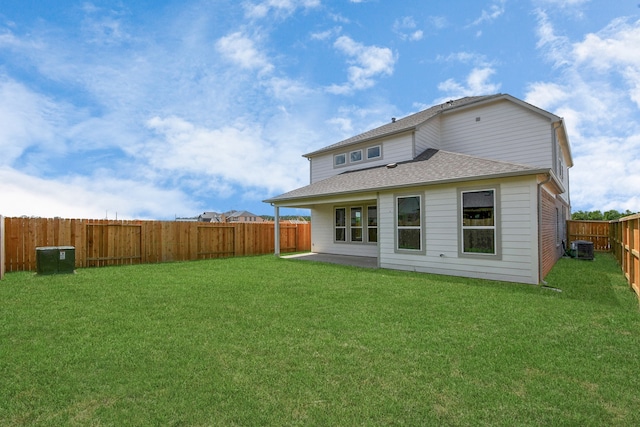 rear view of property with a yard and central AC unit