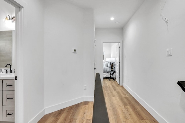 hall with sink and light hardwood / wood-style floors