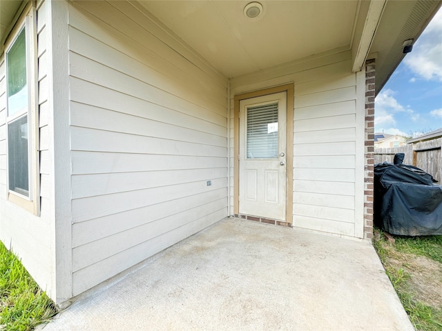 view of exterior entry featuring a patio area