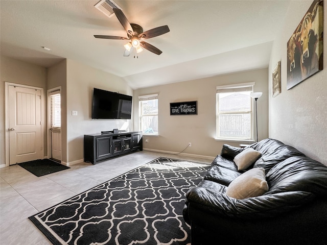 living room featuring lofted ceiling, light tile patterned floors, and ceiling fan