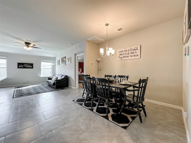 dining space featuring light tile patterned flooring and ceiling fan with notable chandelier