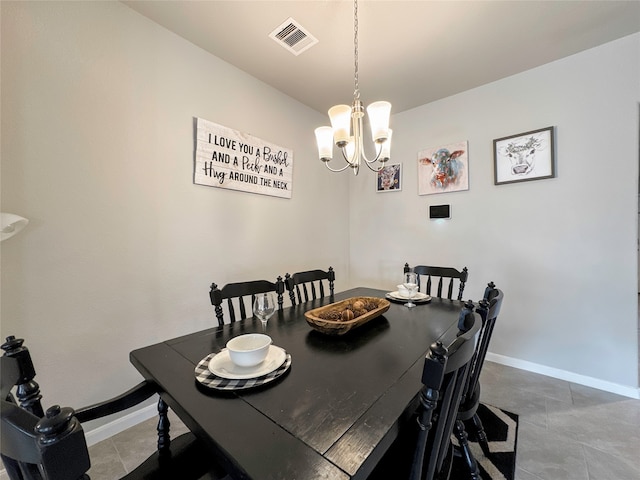 dining area with a chandelier and tile patterned flooring