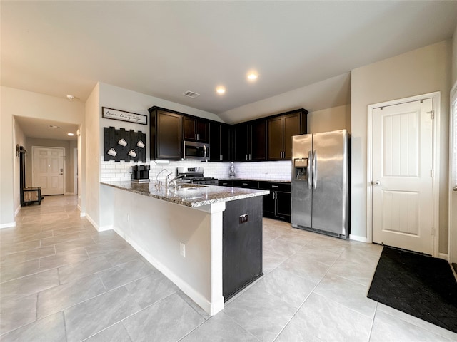 kitchen featuring kitchen peninsula, dark brown cabinets, backsplash, light stone countertops, and appliances with stainless steel finishes